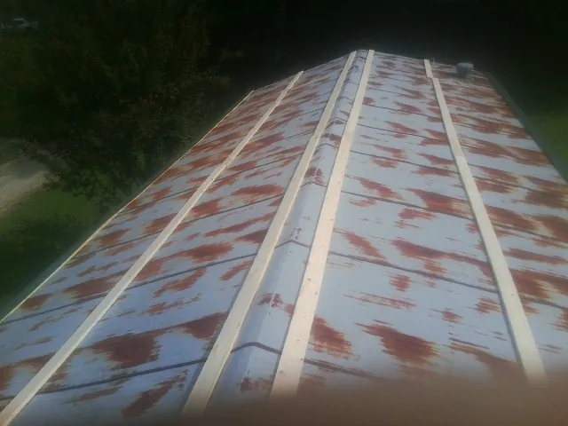 Rusted metal roof panels with new wood purlins before replacement — Storm Damage Roof Repair in Spraggs by Roofing Brothers