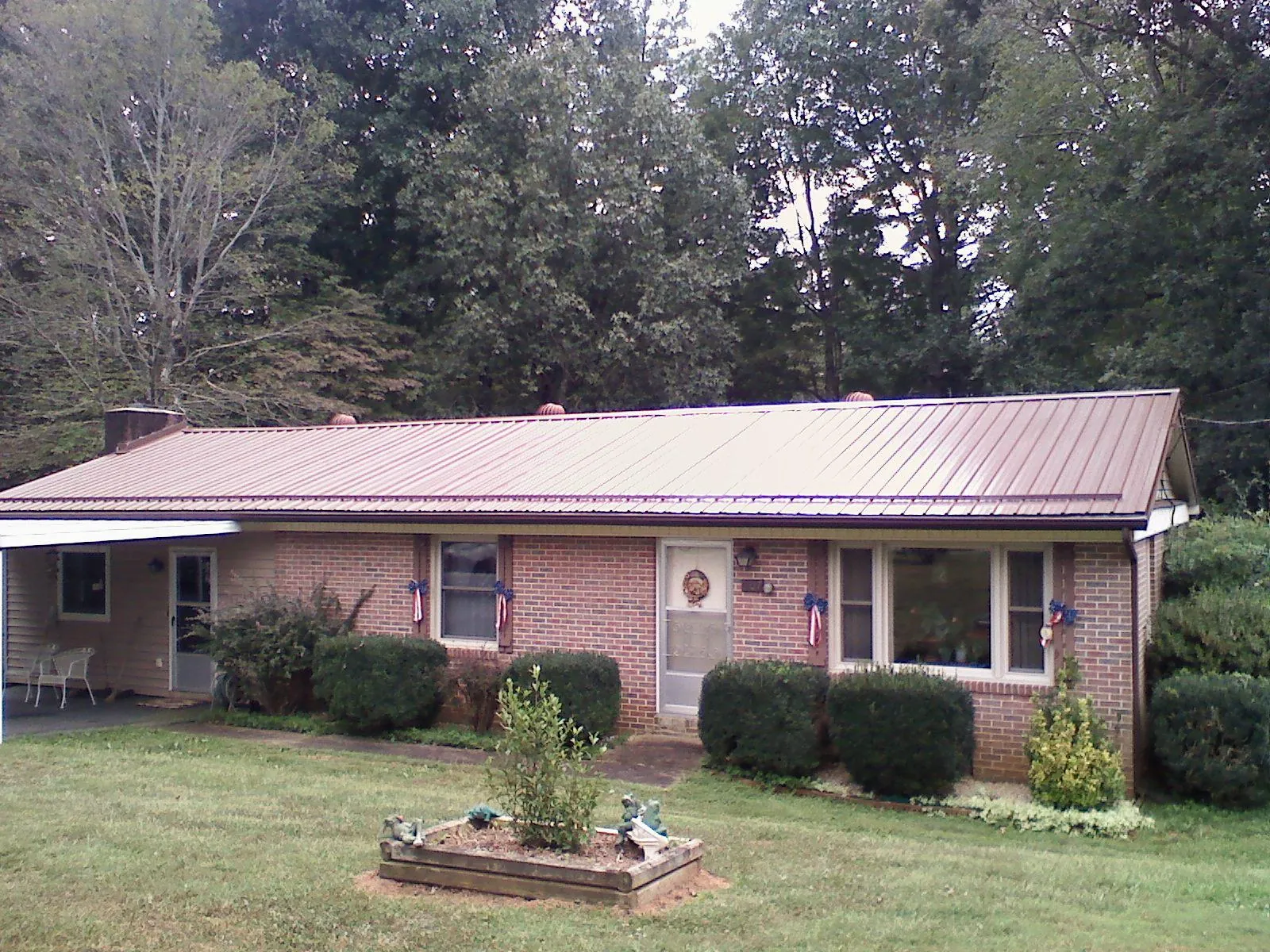 Bronze metal roof on a brick ranch home with a carport in Spraggs