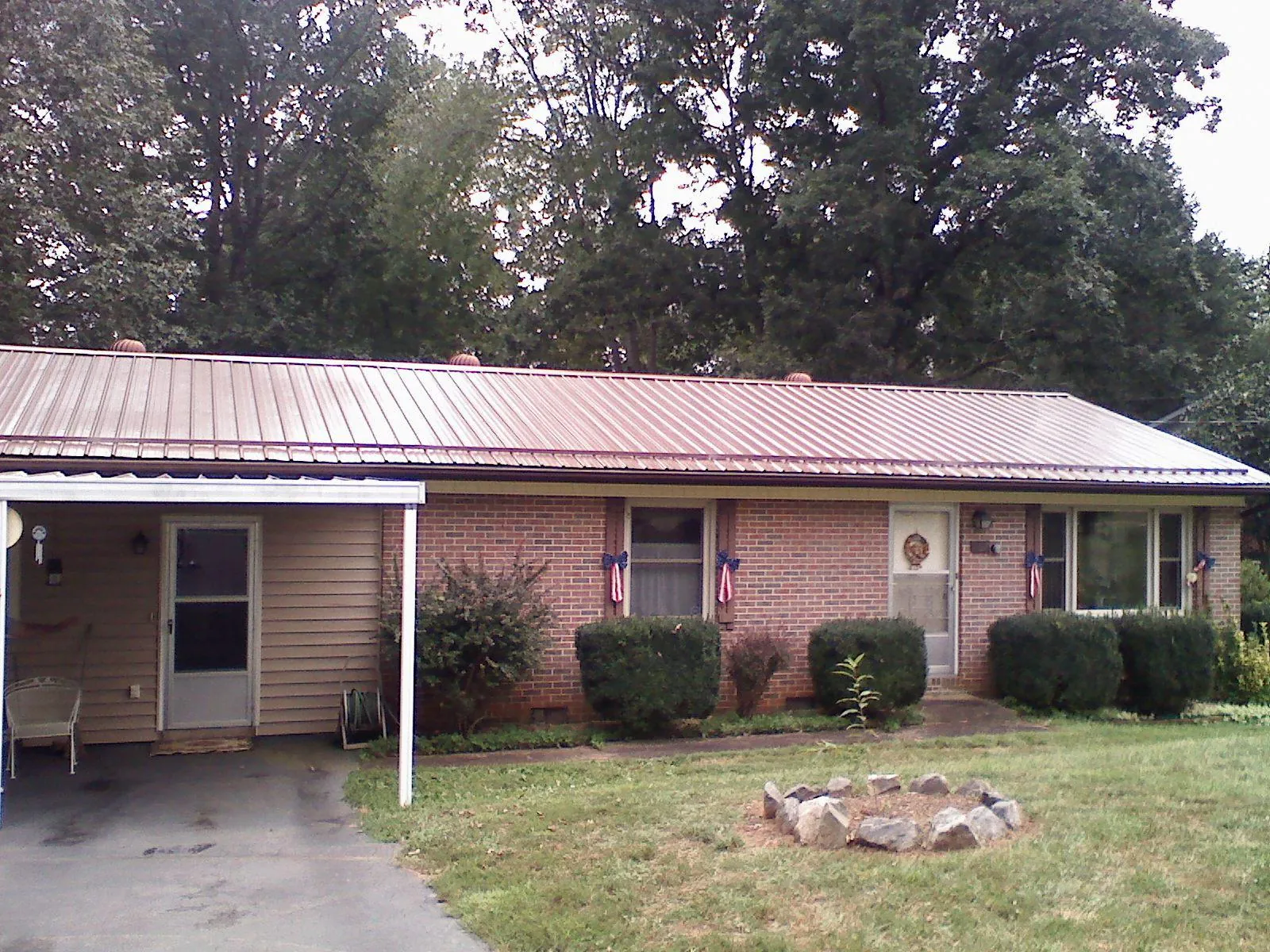 Bronze metal roof and carport on a brick ranch home — Roof Repair work by our crew in Spraggs
