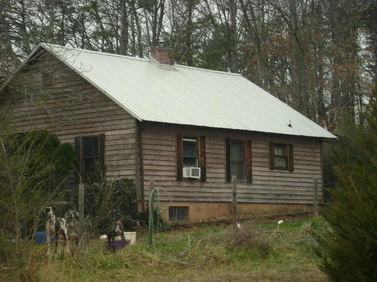 White metal roof on an old wood sided farmhouse, from a Metal Roof Installation job in Spraggs